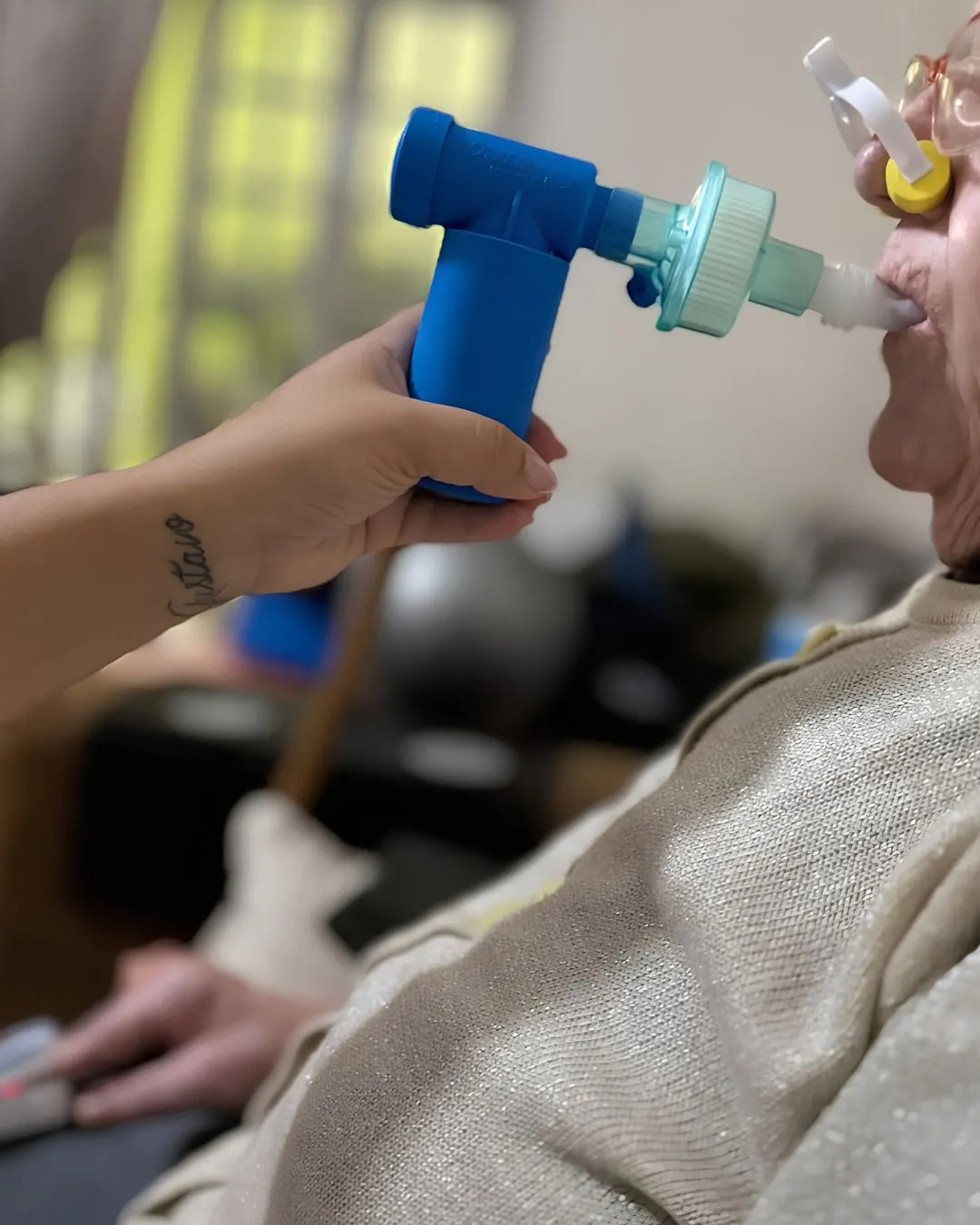 Aplicação de dispositivo de fisioterapia respiratória nas mãos da fisioterapeuta.